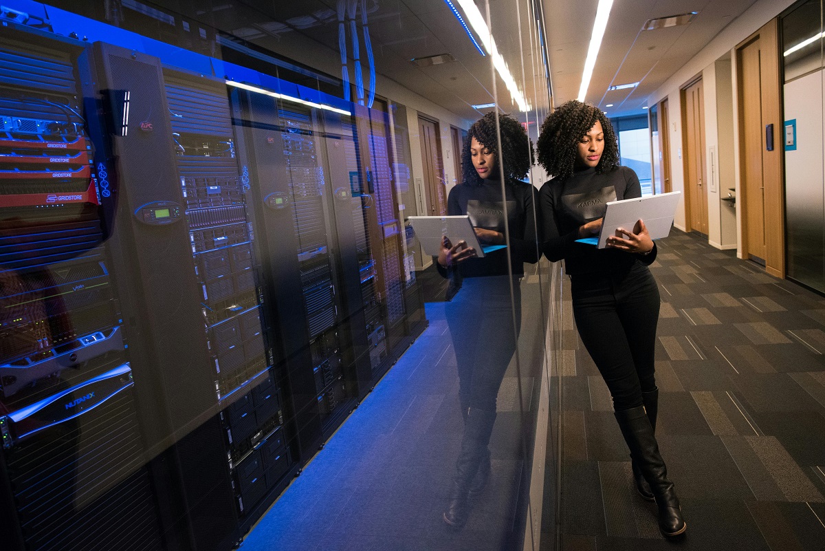 IT professional holding a laptop while standing in a data room