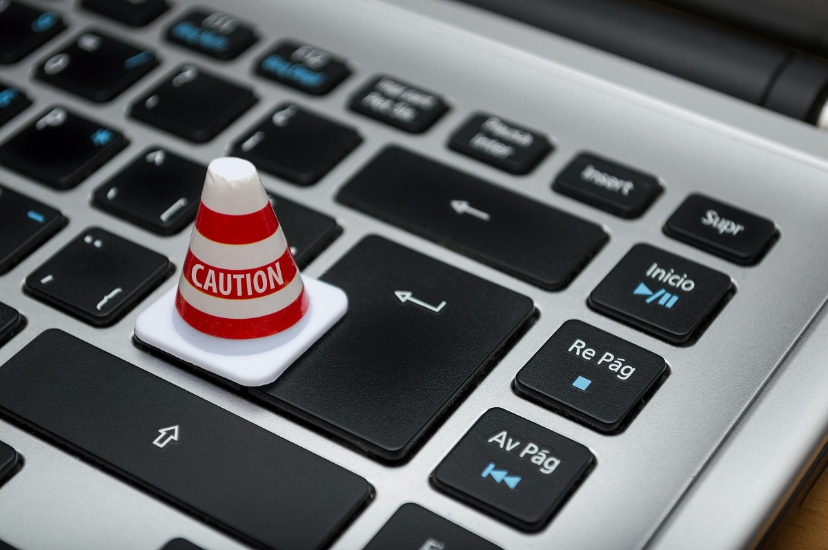 mini 'caution' traffic cone on a laptop keyboard